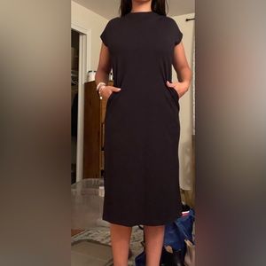 Black dress with pockets. It has a have cut in back